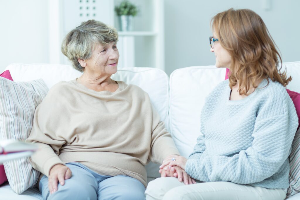 Une patiente assise sur un canapé avec un de ses proches.