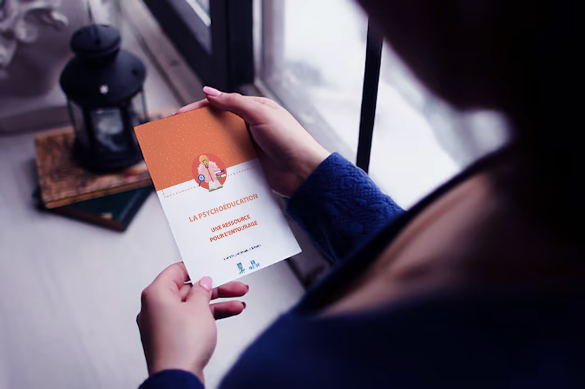 Femme tenant dans les mains un flyer sur la psychoéducation au CPN.