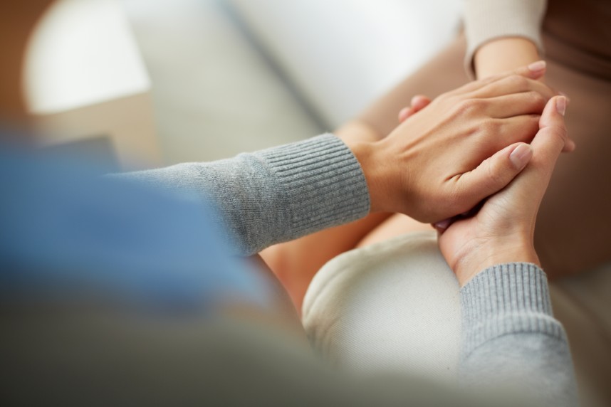 Un soignant montre de la compassion envers un patient en lui tenant les mains.