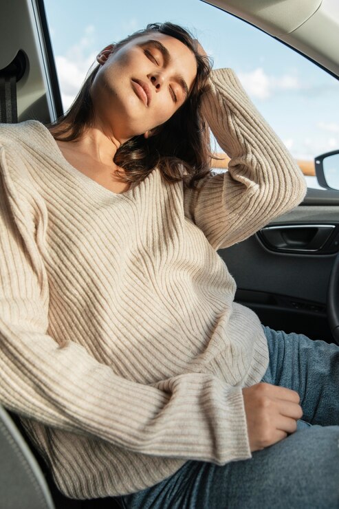 Femme faisant une pause dans sa conduite pour dormir.