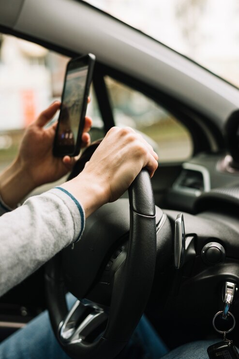 Homme conduisant et utilisant son téléphone en même temps.