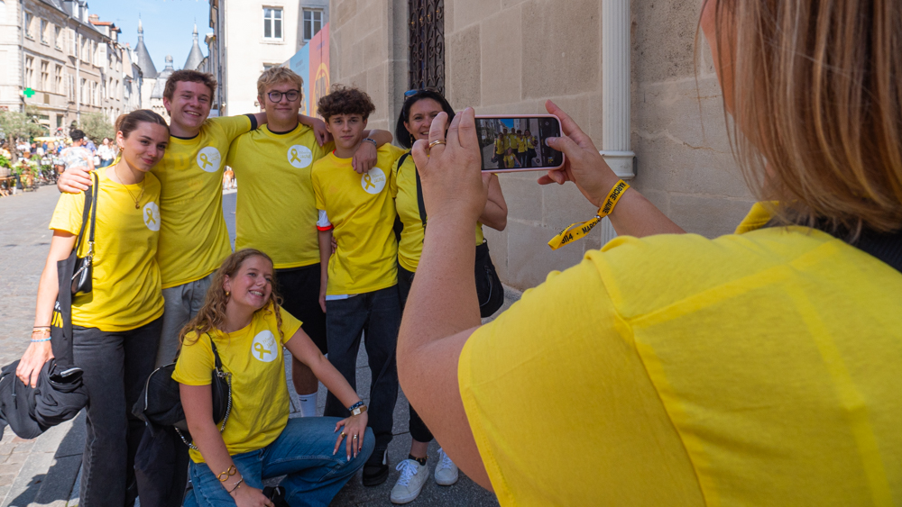 Une famille se prend en photo portant les t shirts de la marche jaune.