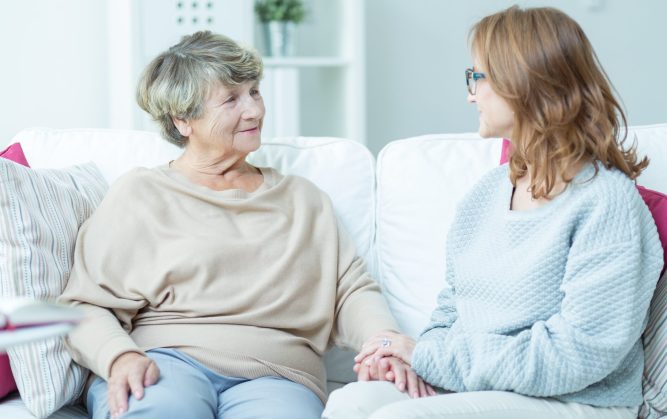 Une patiente assise sur un canapé avec un de ses proches.